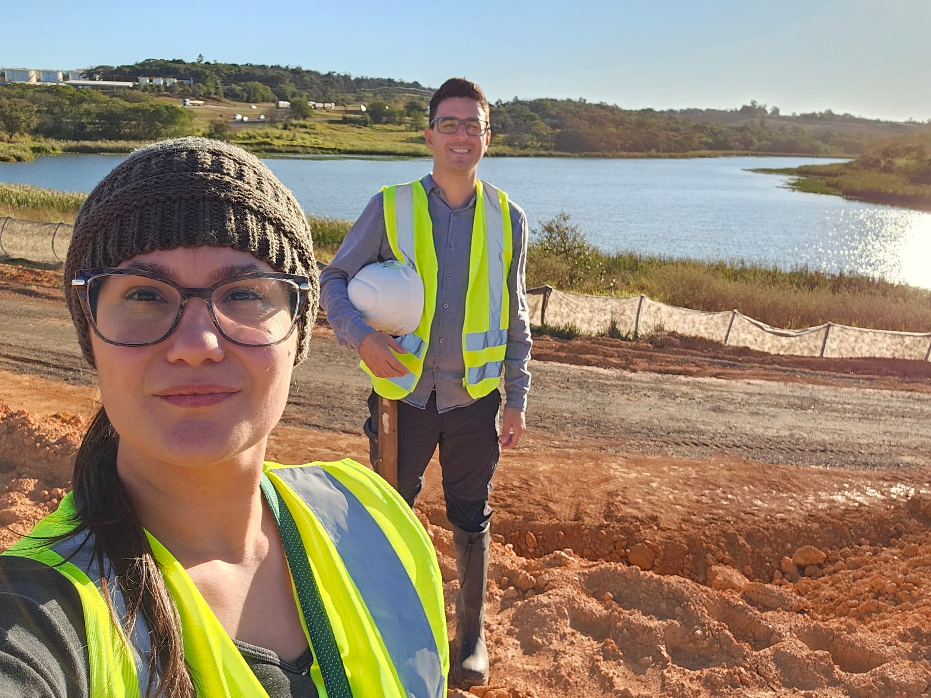 Equipe da Jaçanã Ambiental em campo, com EPIs, ao lado de uma represa